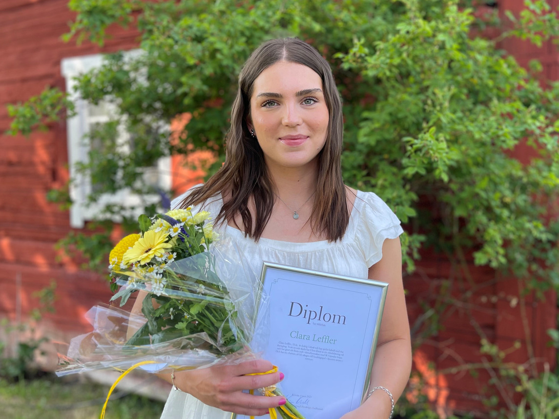 Clara Leffler med blommor och diplom